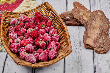 Healthy fresh raspberries in wooden basket with carved rug