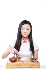 Wearing cheongsam Oriental young woman in preparation for the tea ceremony