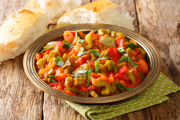 Moroccan food taktouka pepper and tomato salad with garlic dressed with olive oil close-up in a plate on the table. horizontal