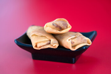 Fried spring rolls at the beginning of spring on a red background