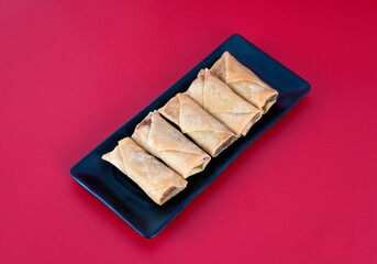 Fried spring rolls at the beginning of spring on a red background