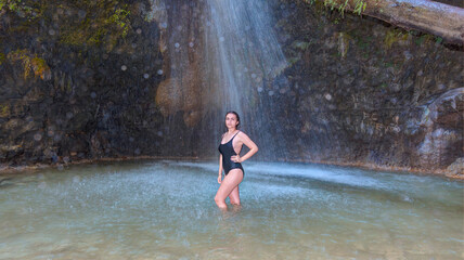 Fototapeta premium Girl washing her hair in the mountain stream, Gizlikent waterfall - Fethiye, Turkey