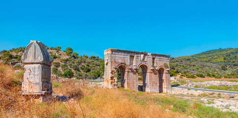 Fototapeta na wymiar Ancient ruins of gates in Patara - Arch of Modestus in ancient Lycian city Patara - Kas, Antalya, Turkey.