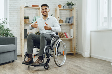 Happy smiling young man in a wheelchair at home