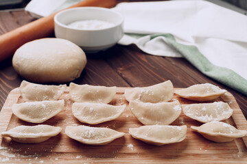 Raw stuffed russian dumplings on wooden board