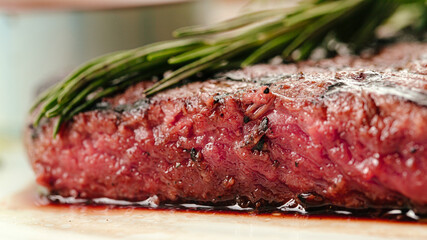 Closeup on roasted beef medium rare steak with a rosemary