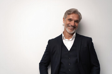 Handsome smiling middle-aged man in suit posing against grey background