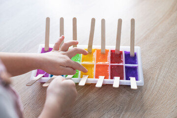 Child take an ice paints. Frozen paint easy process art activity.