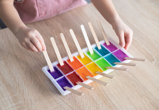 Child take an ice paints. Frozen paint easy process art activity.
