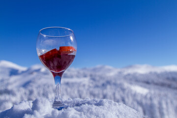 glass of red wine on snow