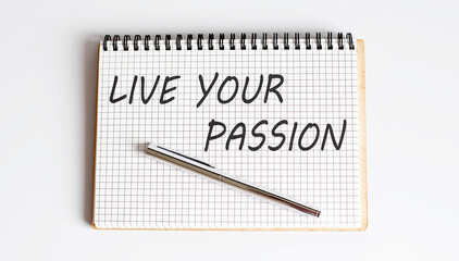 Notebook with pen , text Live Your Passion ,concept