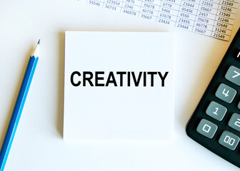 On the sheets for notes text Creativity, next to the calculator and blue pencil, reports.