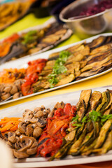 Healthy nutrition in vegetarian style: colorful buffet with various vegetables such as zucchini, mushrooms and carrots for self-service on a large tray