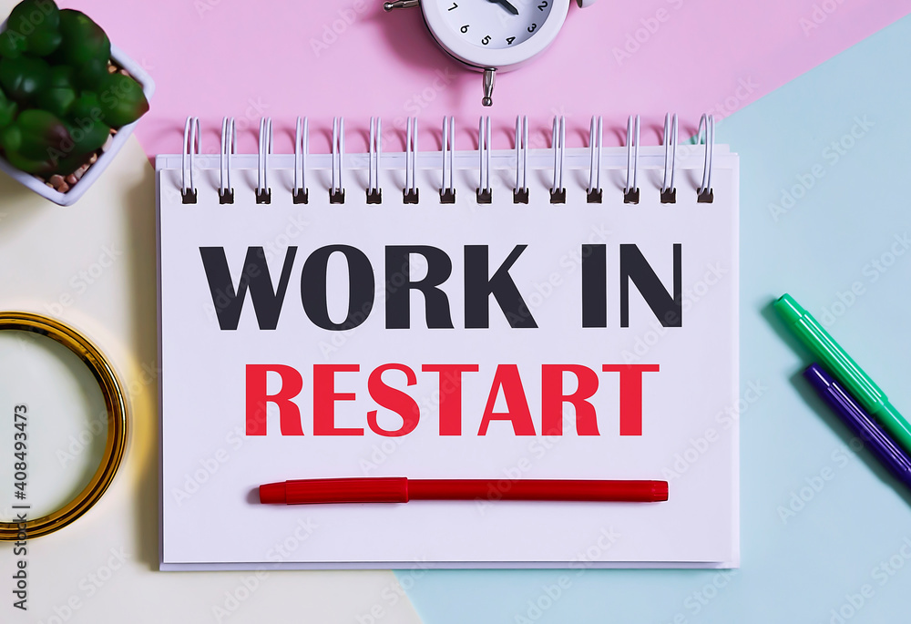 Poster work in restart text written on a notebook with pencils, magnifier