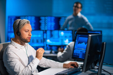 Team of brokers is working in office using workstation and analysis technology. Workplace of professional traders. Global financial markets, business, currency exchange and banking concepts.