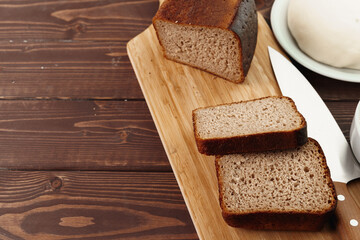 Sliced rye bread on brown wooden background