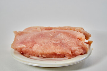 Raw chicken meat on plate on white background