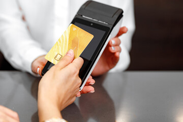 Close up of hand of customer paying with contactless credit card