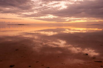 Obraz premium Peaceful sunrise with its colors reflecting in the calm sea at Nakano beach. Iriomote island.