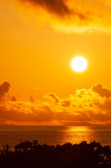 Radiant sunrise with orange and yellow colors, and the beautiful sun reflecting off the Okinawa Sea. Iriomote Island.