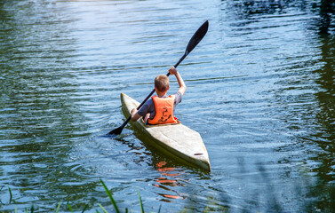 Youth floating in a canoe on the river
