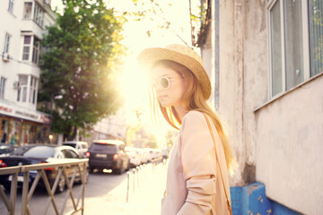 Fototapeta na wymiar woman in hat walking in the city sunny day lifestyle