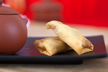 Fried spring rolls and teapots on the plate