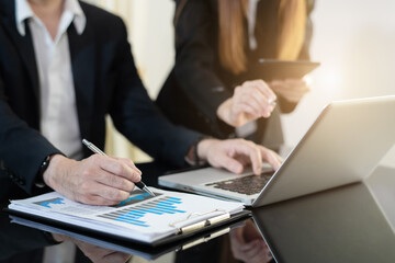 Businessman working as a team start meeting the new marketing project plan By business people using tablets and graph documents Calculate the amount of money for the project.