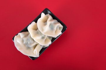 A plate of Chinese festival dumplings on a red background