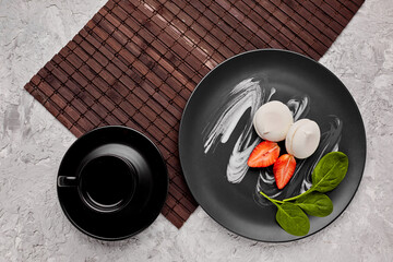 Homemade marshmallow on a gray plate with strawberries and a green leaf. Marshmallow with a cup of...