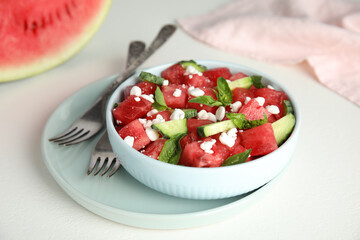Delicious salad with watermelon, cucumber and cheese on white table, closeup