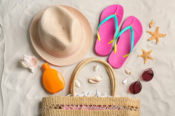 Different beach accessories on sand, flat lay