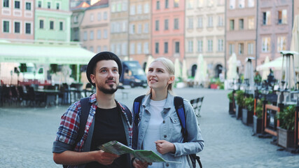 Fototapeta premium Happy couple of tourists looking on main tourist attractions using map. They are so happy to go sightseeing.