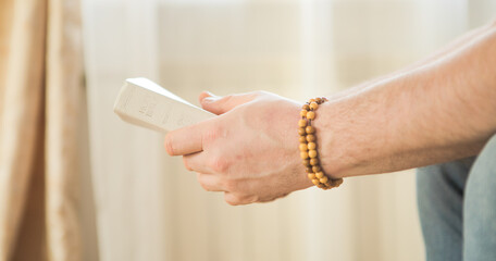 Obraz premium The Christian holds the Bible in his hands. Reading the bible. The concept of faith, spirituality and religion