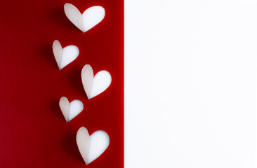 Placed hearts on a red-white background with space for writing text.