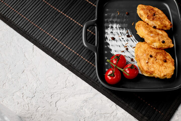 Traditional chicken schnitzel and cherry tomatoes on a gray concrete background. Chicken cutlets...