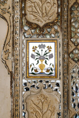Floral pattern in mirror decorating a wall in Amber Fort, India