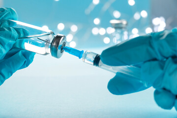 Doctor, nurse, scientist, researcher hand in blue gloves holding flu, measles, coronavirus, covid-19 vaccine disease preparing for human clinical trials vaccination shot, medicine concept.