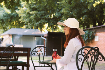 Young pensive woman having a drink in a cafe.