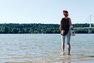 Rear view of redhead woman at the river.