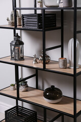 Shelving with different decor near white wall. Interior design
