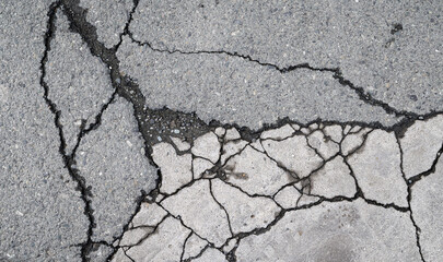 Asphalt road with small rocks and cracks.