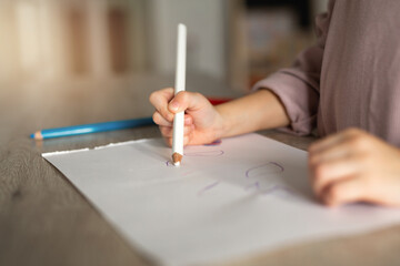 beautiful little girl draws with a pencil at home 