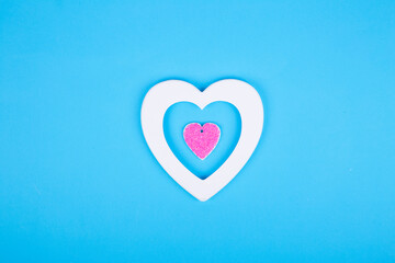 Minimal composition with white and pink hearts on pastel blue background. Valentines day concept.