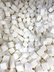 Many sugar cubes on the market. Overhead view of pressed sweetener
