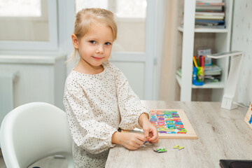 beautiful little girl playing educational game at home 
