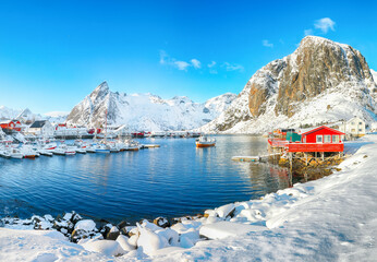 Gorgeous winter view on Hamnoy village with port and Festhaeltinden and Olstinden peaks on background.