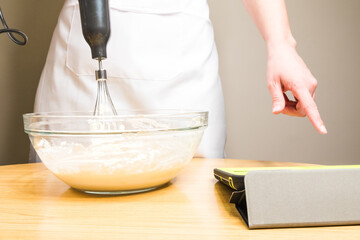 Closeup of a person mixing batter for cheesecake in a bowl on the table