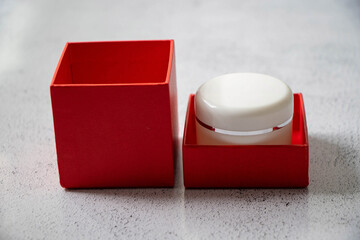 Luxury red box and a white cosmetic jar. Product concept