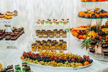 Buffet table with sweets and fruits.